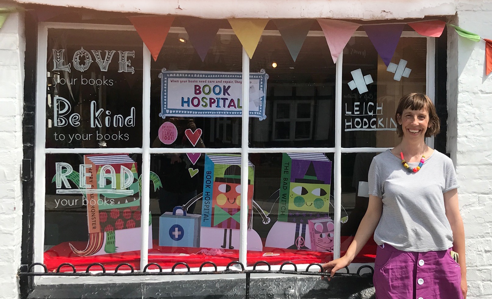Illustrator Leigh Hodgkinson by the decorated window of Bags of Books