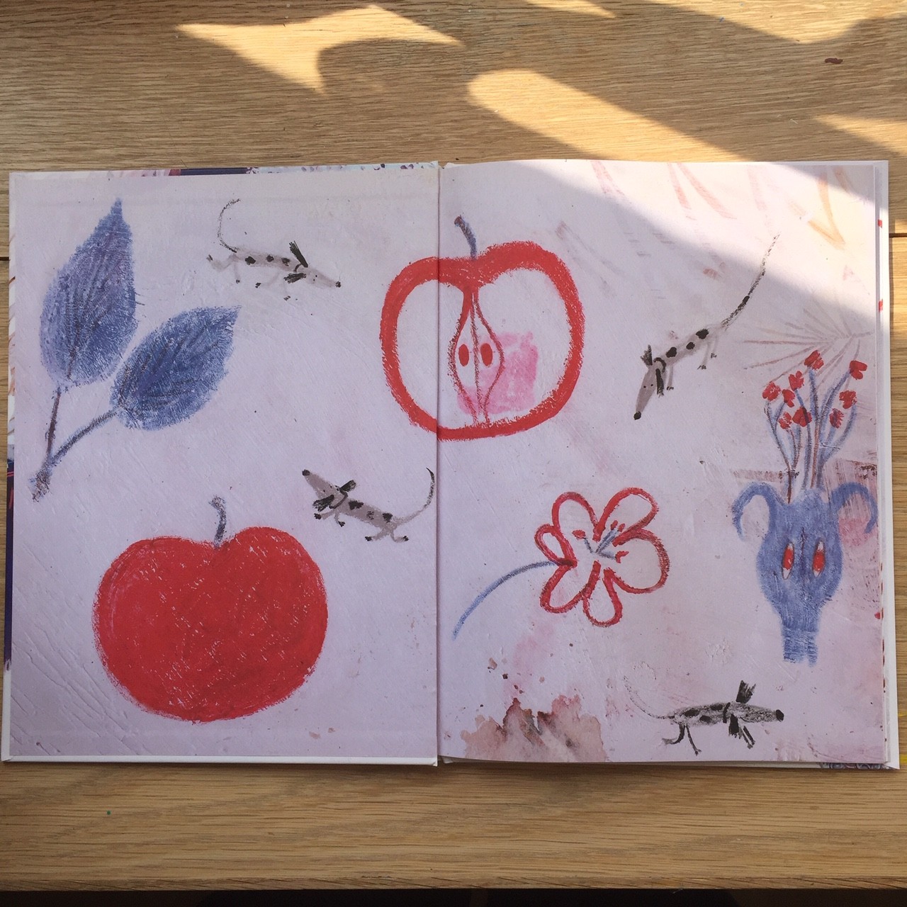 endpapers from a childrens book with drawings of apples, flowers and dogs